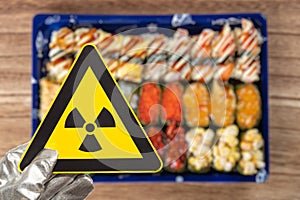 a nuclear radiation warning sign above blurred sushi horizontal composition