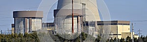 Nuclear reactor containment buildings with cooling tower in background