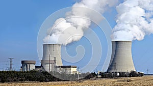 Nuclear reactor containment buildings with cooling tower in background