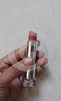 Nude lipstick in a hand