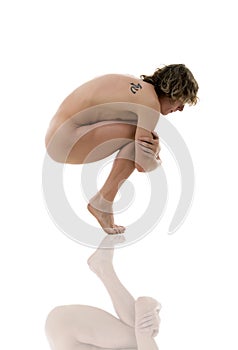 Nude person in a fetal position