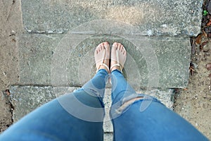 Nude Shoes Woman and Yellow Pineapple Shirt Accessories. Close Up on Girl`s Feet Wearing Nude Sandals and Lack of Blue Jeans on S