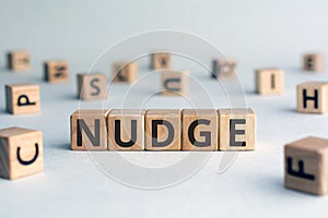 Nudge - word from wooden blocks with letters photo