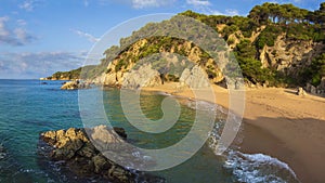 Nudist beach in Spain, Cala sa Boadella, Costa Brava, Lloret de Mar. Sandy spanish beach with rocks and stones in water