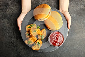 Nuggets, two cheeseburgers and chili sauce on slate board