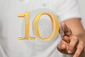 Number 10 behind a person's fingers