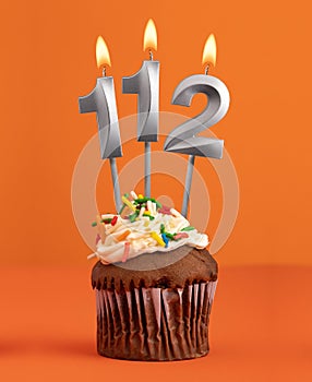 Number 112 candle - Birthday cupcake on orange background