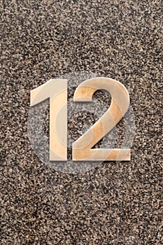 Number 12 metal house number on stone wall