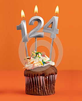 Number 124 candle - Birthday cupcake on orange background