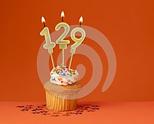 Number 129 candle - Birthday card design in orange background