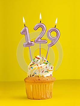 Number 129 candle - Birthday card design in yellow background