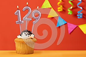 Number 129 Candle - Birthday cupcake on orange background with bunting