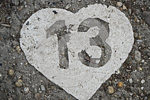 Number 13 in a heart painted on concrete