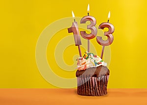 Number 133 birthday candle - Celebration on yellow background
