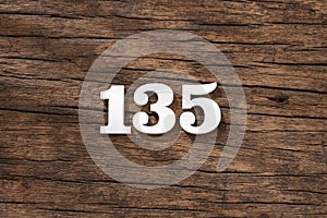 Number 135 in wood, isolated on rustic background