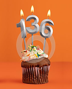 Number 136 candle - Birthday cupcake on orange background