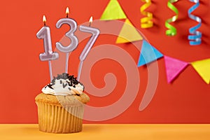 Number 137 candle - Birthday cupcake on orange background with bunting