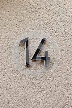 Number 14 black house number on white wall