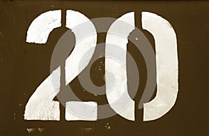 Number 20 in stencil on metal wall in brown tone