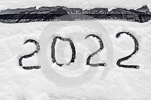 Number 2022 is symbol of next New Year, written freshly fallen snow that lies on windshield of car