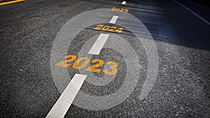 Number of 2023 to 2025 on asphalt road surface with marking lines