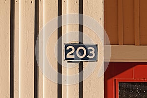 Number 203 on a sign and wood on which the spring light falls differently