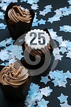 Number 25 on Delicious chocolate cupcake with cream on dark background. Muffin. Birthday cake party. 25 years old