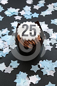Number 25 on Delicious chocolate cupcake with cream on dark background. Muffin. Birthday cake party. 25 years old anniversary