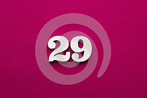 Number 29 - White wooden number on rhodamine red background