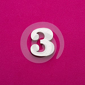 Number 3 - White wooden number on rhodamine red background
