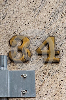 Number 34 tarnished brass house number on granite wall