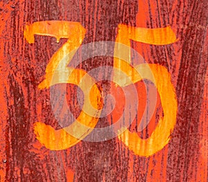 The number 35 on a rusty metal fence