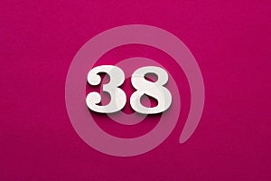 Number 38 - white number in wood on rhodamine red background