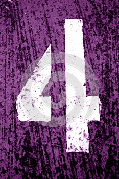 Number 4 in stencil on grungy metal wall in purple tone