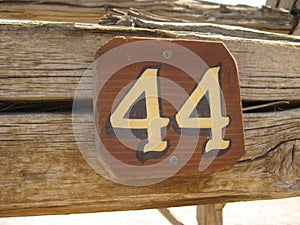 Number 44 Sign Attached to Old Wooden Item