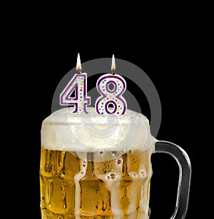 Number 48 candle in beer on black