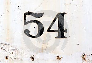 Number 54 plated on rusty white painted surface