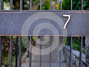 Number 7 seven on a gate.