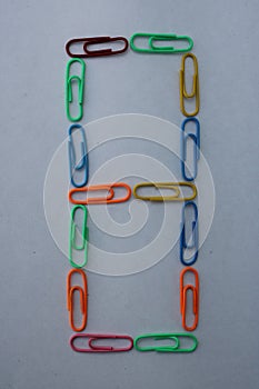 Number 8 made with colorful paper clips on white background