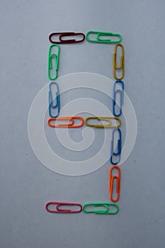 Number 9 made with colorful paper clips on white background