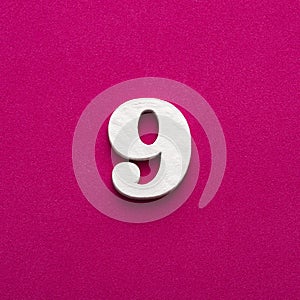 Number 9 - White wooden number on rhodamine red background