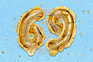 The number of the balloon made of golden foil, the number sixty-nine on a blue background with sequins