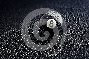 Number eight billiard ball with water drops on a black background