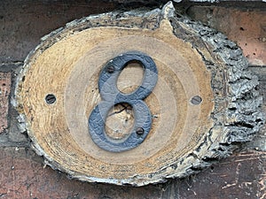 Number eight door sign attached to an old weathered tree stump