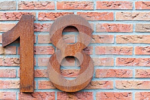 Number eighteen in red on a brick wall