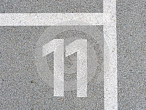 Number eleven painted on soft rubber surface. Eleventh place. Jumping hopscotch