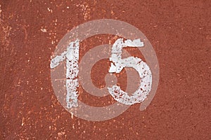 The number fifteen in white on an old red wall