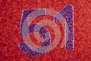 Number fifty-one purple over a red background. Anniversary.