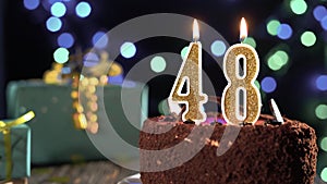 Number forty-eight birthday candle on a sweet cake on the table, 48th birthday. Fire from the lighter, blow out the