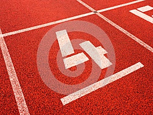 Number four. White track number on red rubber racetrack,